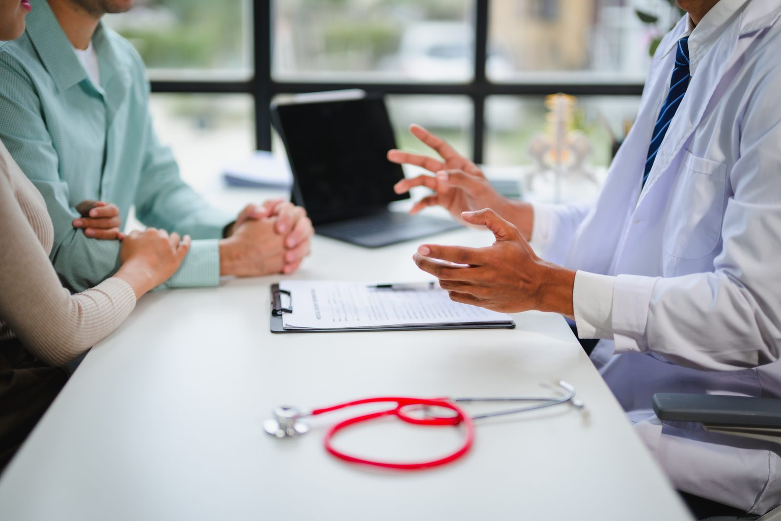 A physician explaining care options to a patient and support person